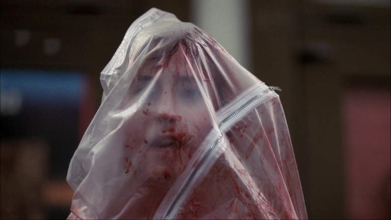Tina is zipped up inside a bloody body bag in A Nightmare on Elm Street (1984).