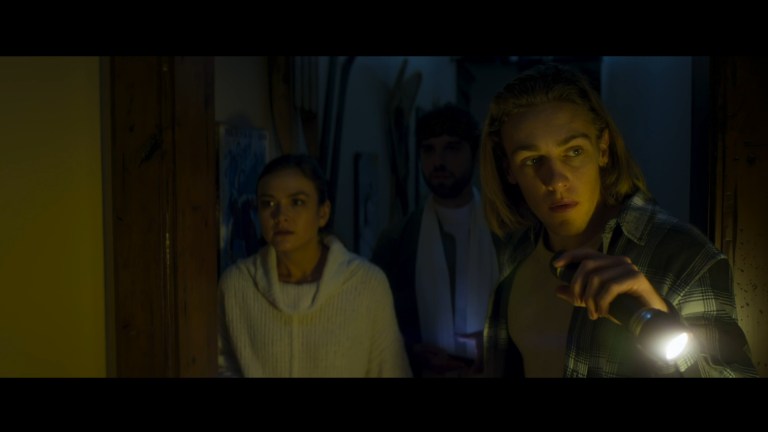 Rachel Michiko Whitney, David Lambert, and Cooper can Grootal walk down a dark hallway in Snow Valley (2024).