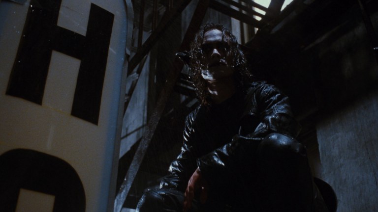 Eric Draven sits on a fire escape in The Crow (1994).