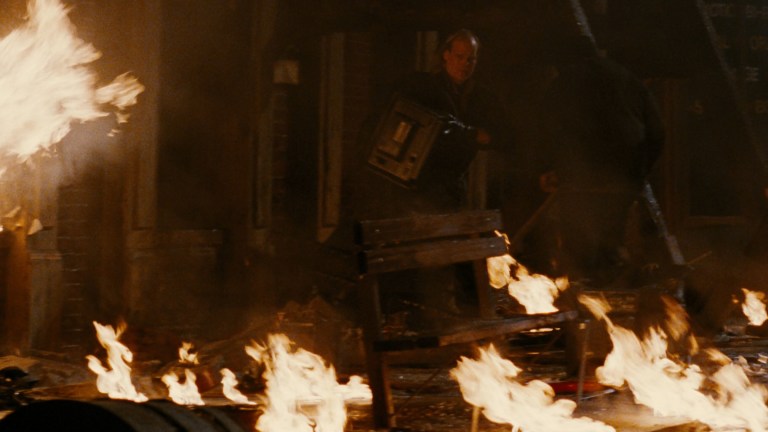 A looter played by James O'Barr steals a TV as everything burns in The Crow (1994).