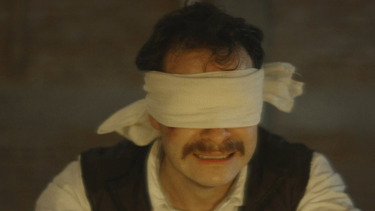 A blindfolded man is scared in The Devil Told Me What to Do (2019).