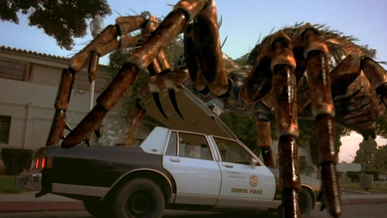 A giant spider crushes a police car in Spiders (2000).