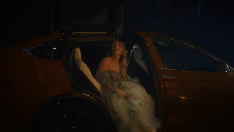Cinderella exits an orange car on her way to the prince's ball in Cinderella's Revenge (2024).