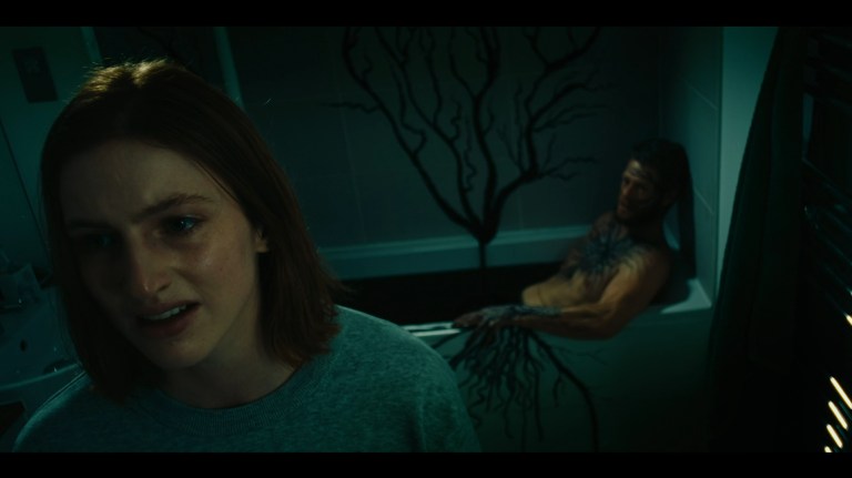 Dakota looks away while Axel sits, infected, in a bathtub in Kill Your Lover (2023).