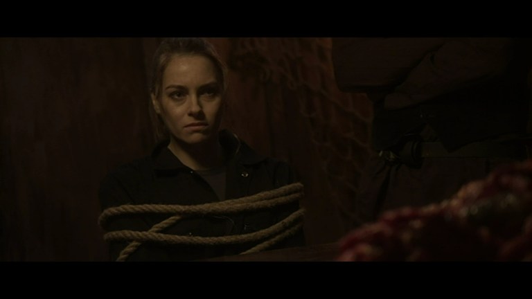 Elena is tied up in Ship of the Damned (2024).