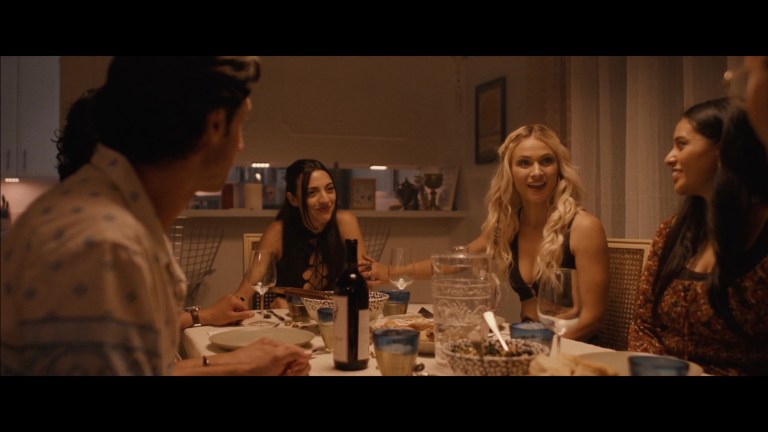 Celeste and her friends smile during dinner in Stupid Games (2024).