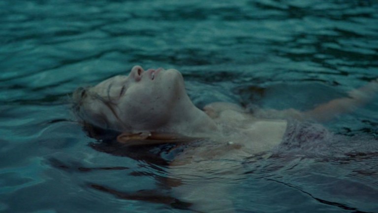 Mari floats in the water in The Last House on the Left (2009).