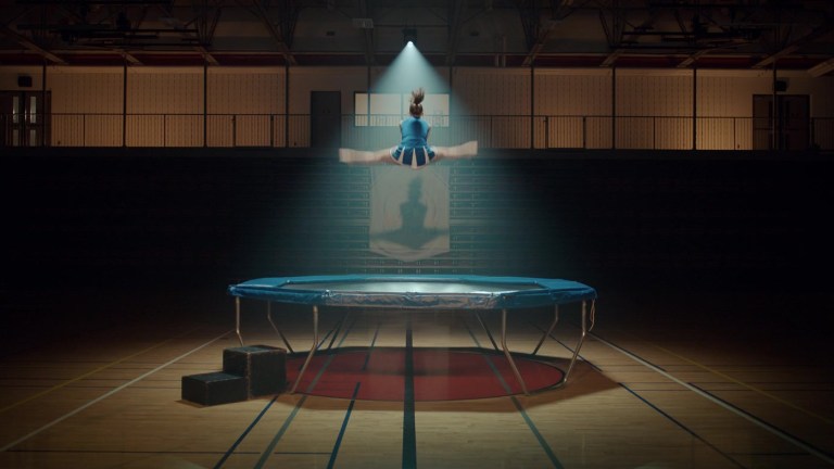 A cheerleader jumps on a trampoline in Thanksgiving (2023).