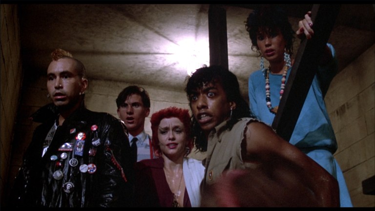The punks look on in horror as the descend in to the basement of the Uneeda warehouse in The Return of the Living Dead (1985).