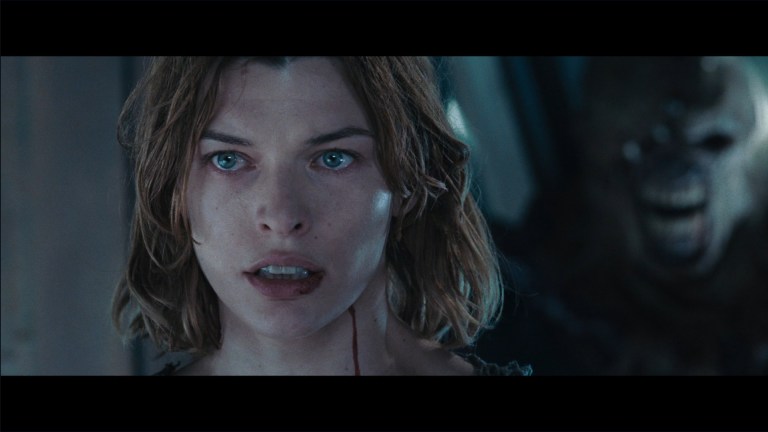 An image from Resident Evil: Apocalypse depicting Milla Jovovich as Alice, and the Nemesis behind her.