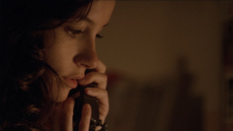 Samantha listens while on the phone in The House of the Devil (2009).