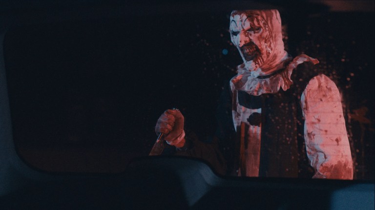 Art the Clown holds a knife in Terrifier 2 (2022).