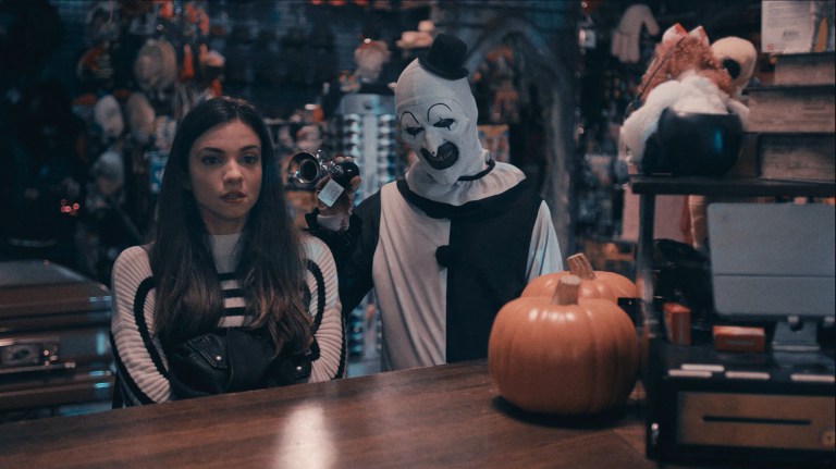 Art holds a horn towards Sienna in Terrifier 2 (2022).