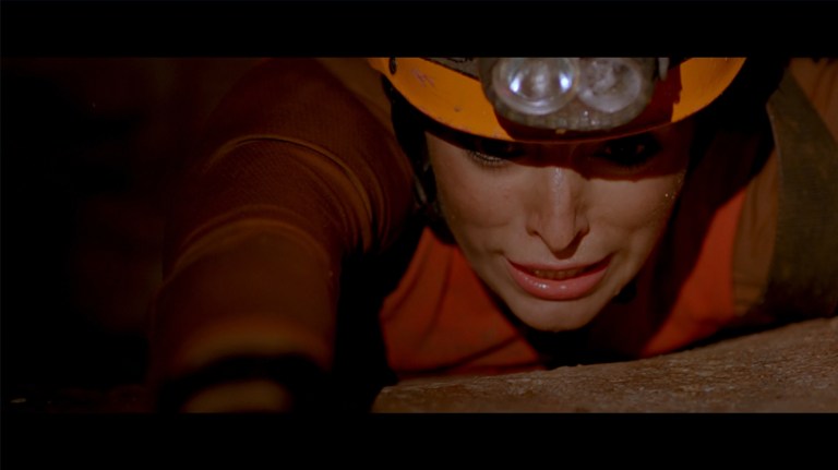 Holly struggles to keep from falling into a pit in The Descent (2005).