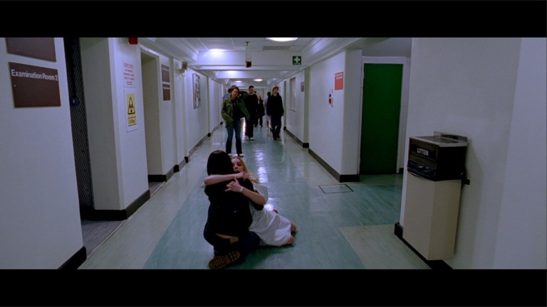 Juno cries as she watches Beth and Sarah hold each other in the hospital in The Descent (2005).