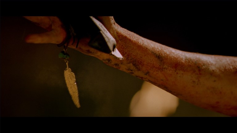 Sarah holds Juno's necklace in The Descent (2005).