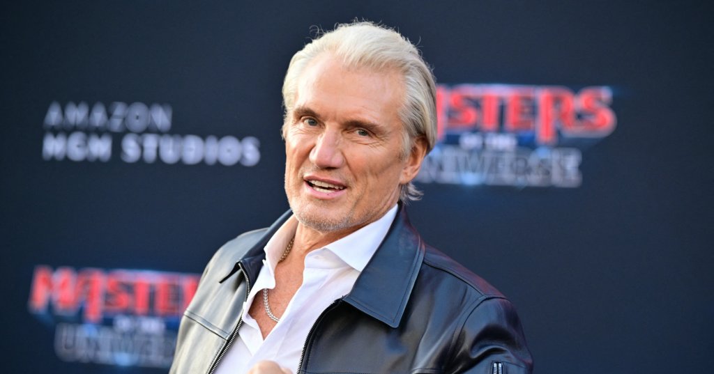 Dolph Lundgren in a black leather jacket raises a fist at the Masters of the Universe premiere at TCL Chinese Theatre in Hollywood.