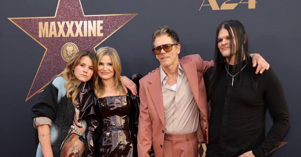 Sosie Bacon, Kyra Sedgwick, Kevin Bacon, and Travis Bacon standing together in front of a MAXXXINE star backdrop at the TCL Chinese Theatre.