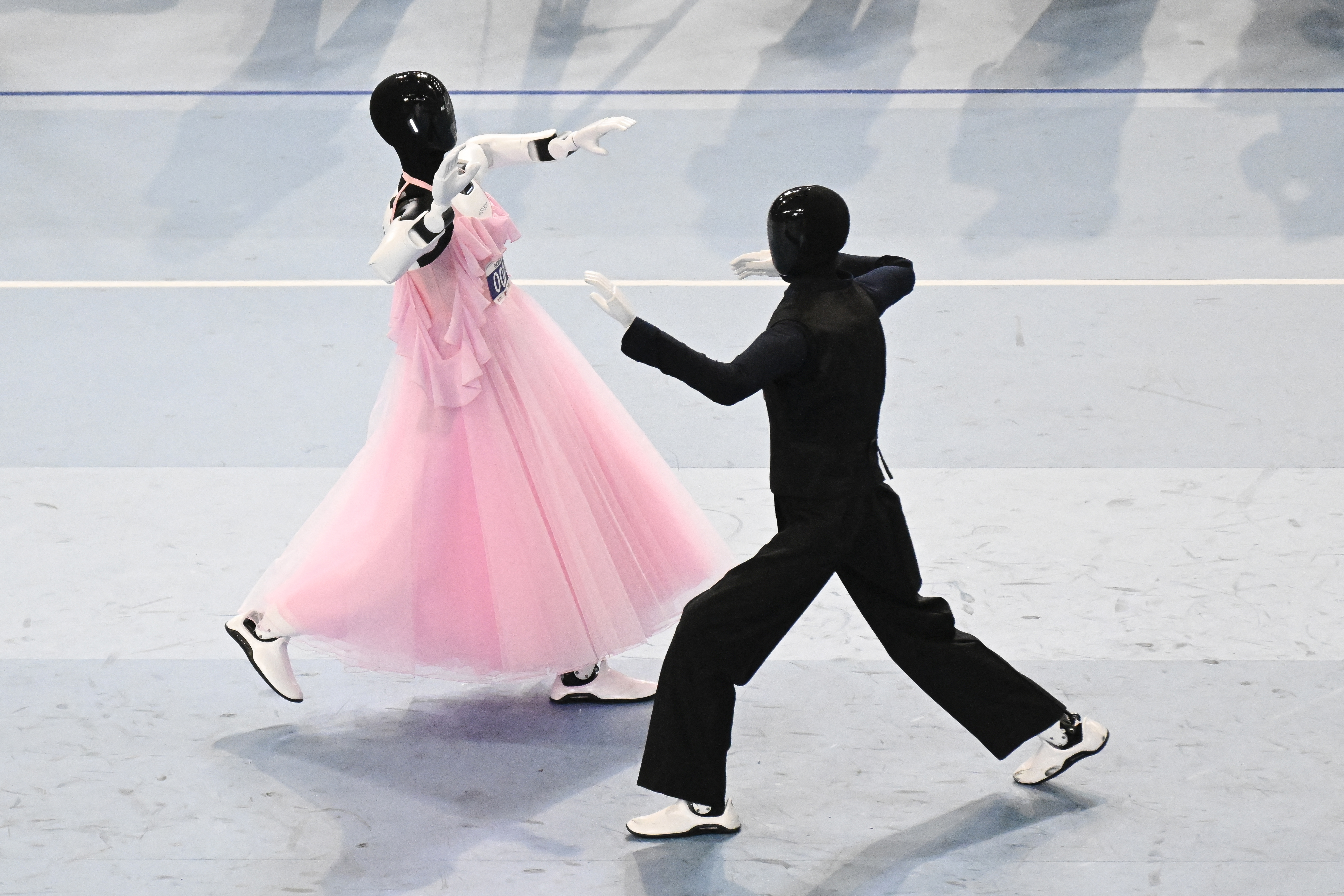 Two humanoid robots dancing at the 2nd World Humanoid Robot Games at the National Speed Skating Oval in Beijing