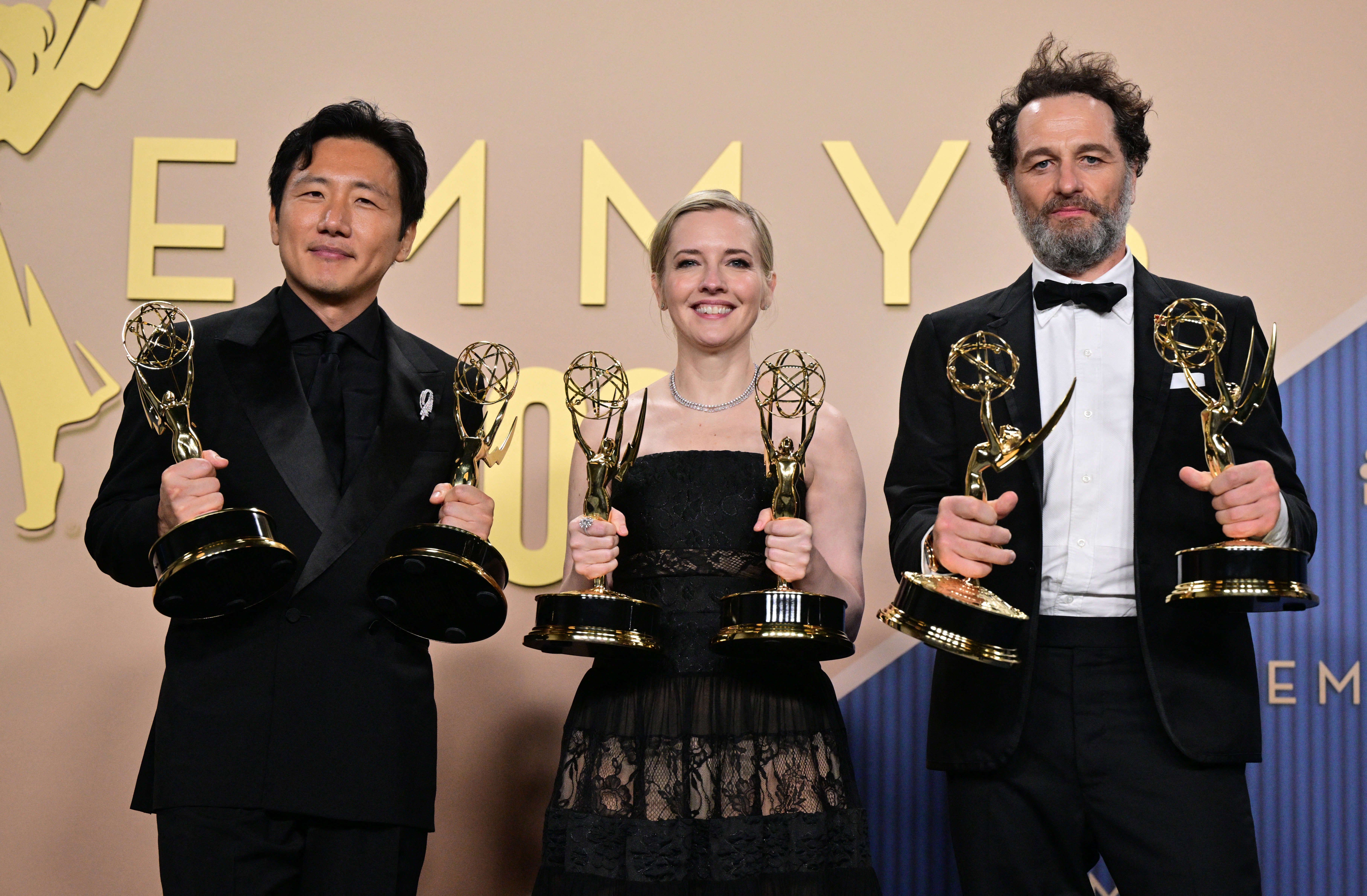 Hiro Murai, Katie Dippold, and Matthew Rhys posing together in the press room at the 78th Primetime Emmy Awards at Peacock Theatre in Los Angeles