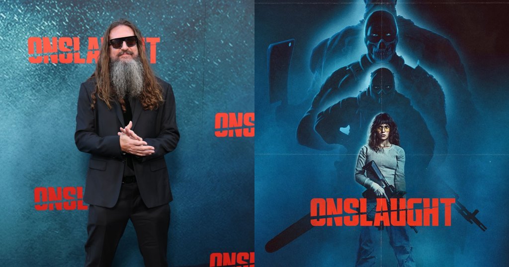 Man with long hair, a long gray beard, and sunglasses wearing an all-black suit at the Onslaught premiere step-and-repeat backdrop.