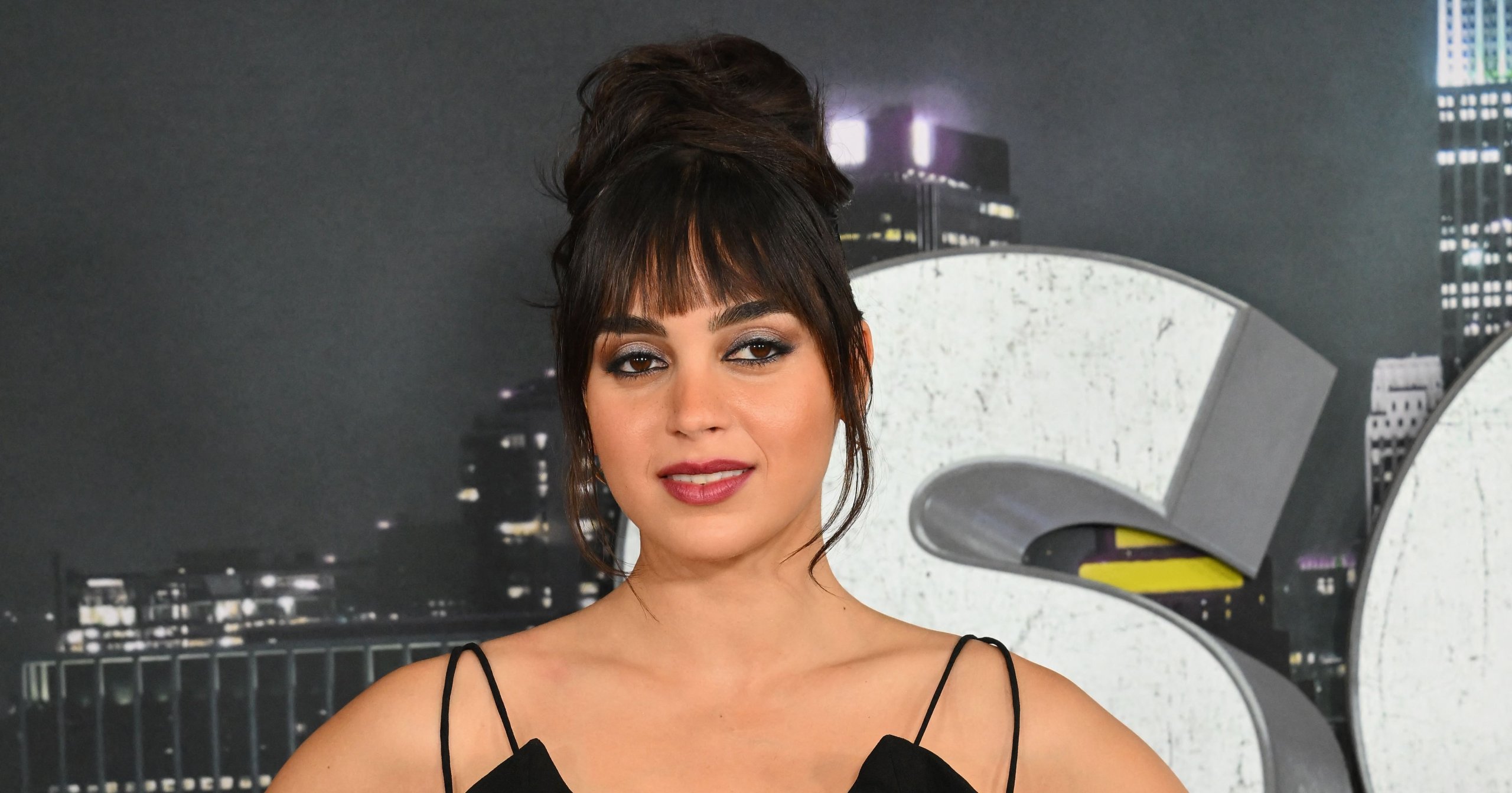 Melissa Barrera in a black cutout dress with ruffles, hands on hips, at the Scream VI world premiere in New York City.