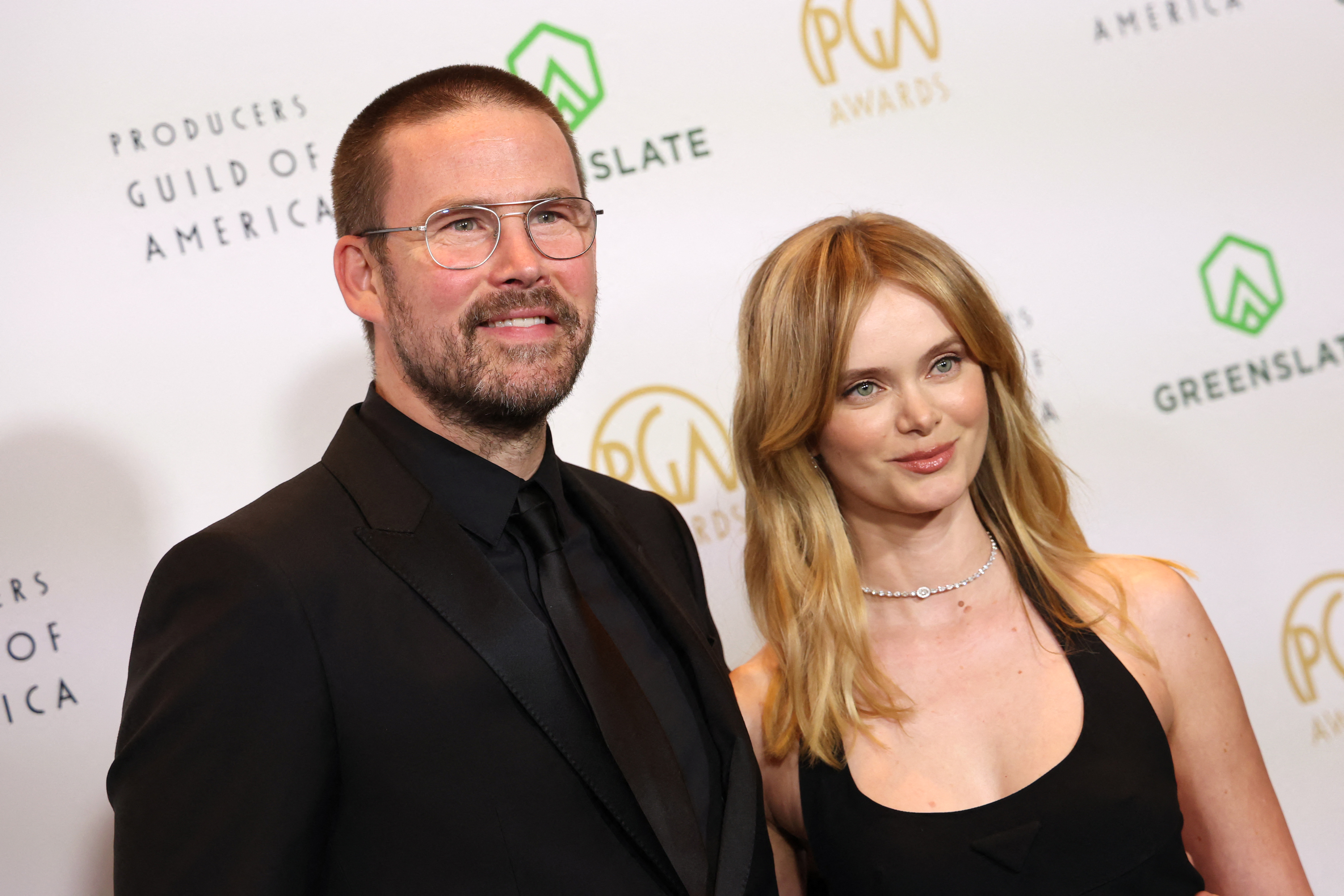 Zach Cregger in a black suit and Sara Paxton in a black dress on the red carpet at the Producers Guild Awards.