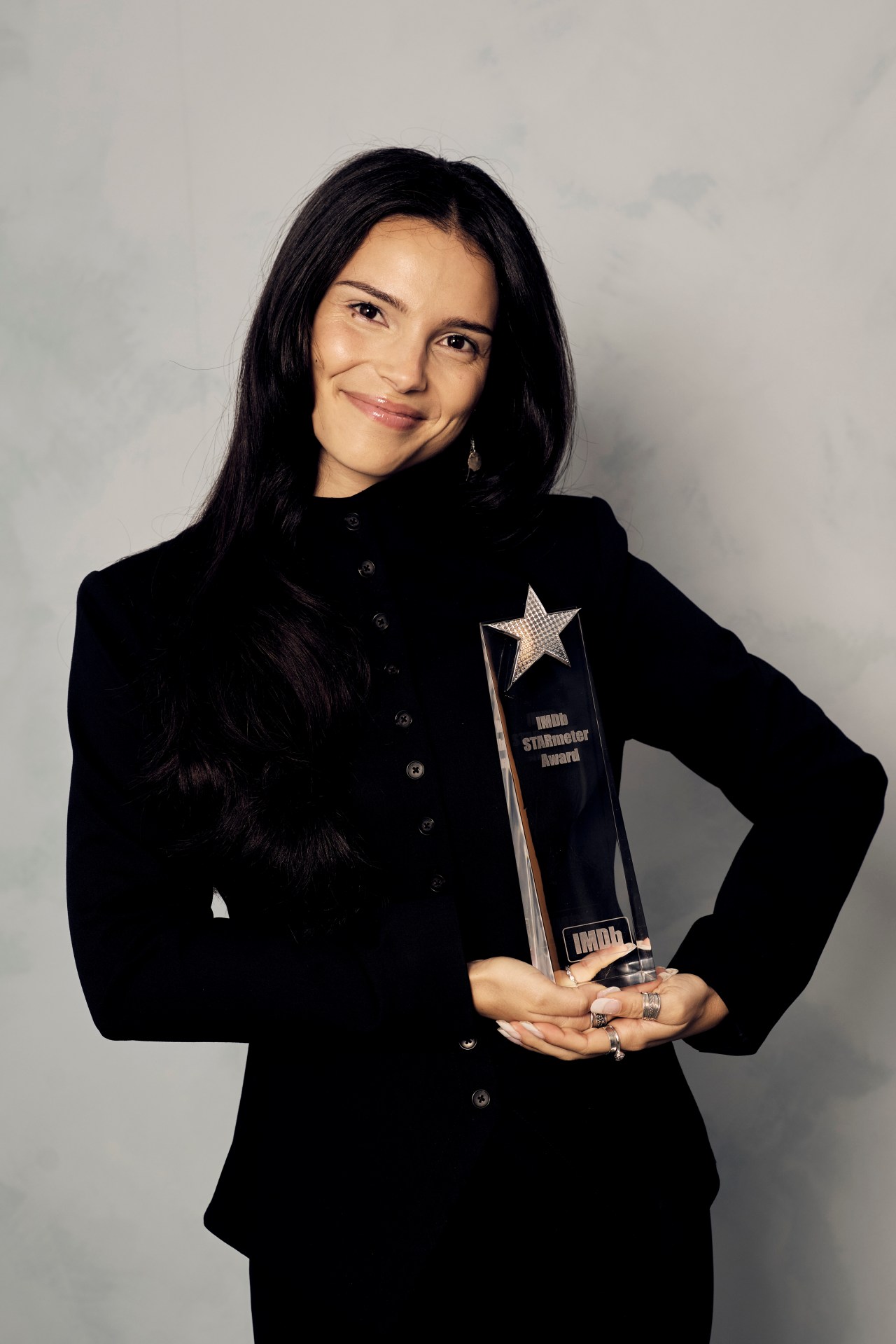 Inde Navarrette smiling and holding an IMDb STARmeter Award trophy at the Intercontinental Hotel in Toronto.