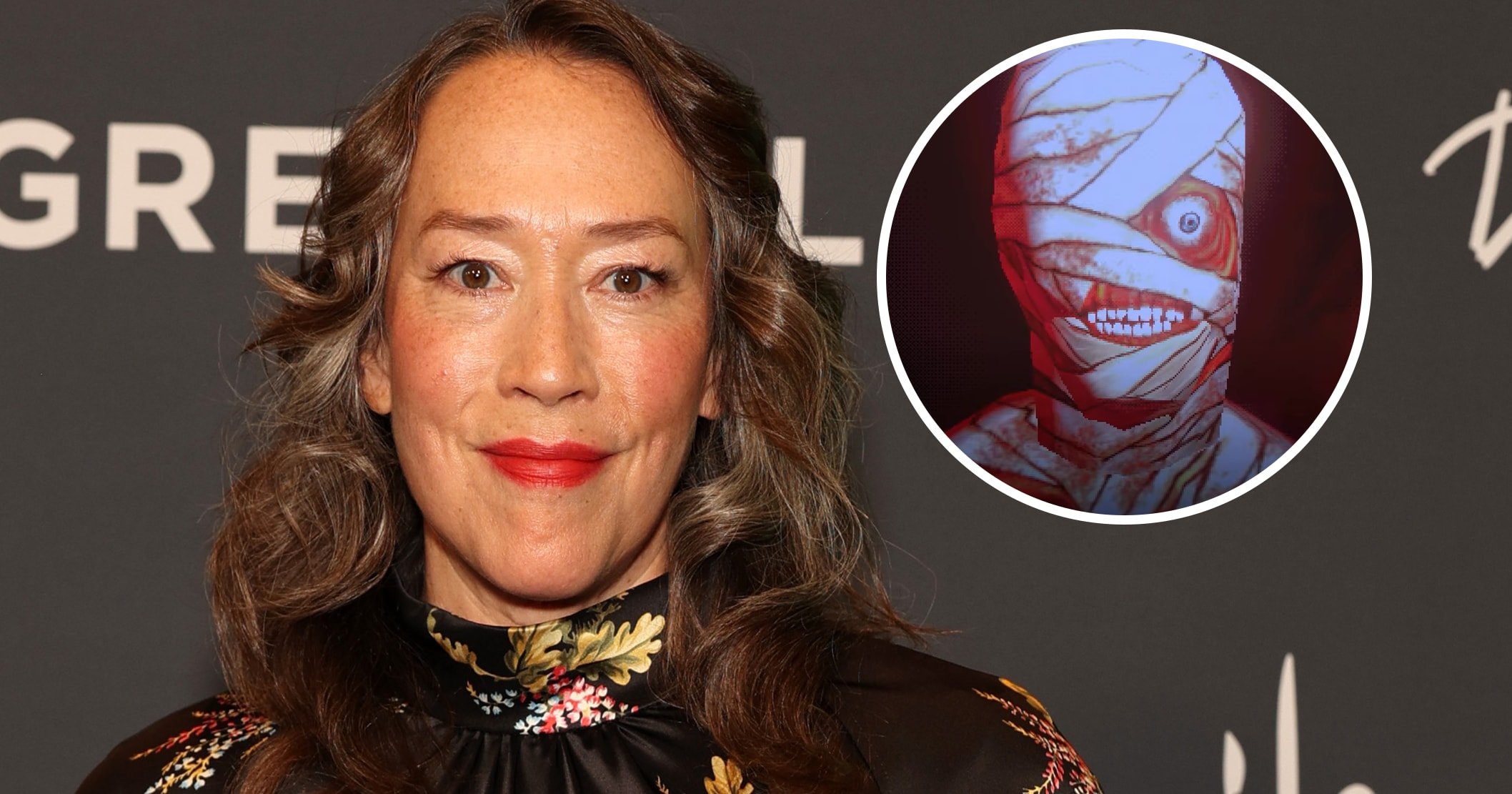 Karyn Kusama in a black floral cape dress at a red carpet event with GreenSlate branding in the background.