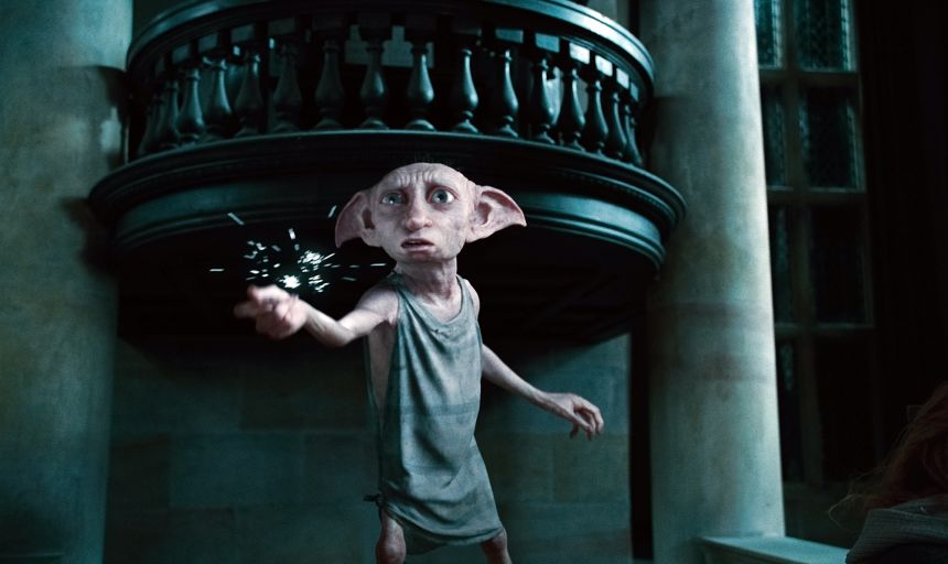 CGI house elf Dobby extending his arm with a burst of magic in a dark interior scene from Harry Potter and the Deathly Hallows: Part 1.