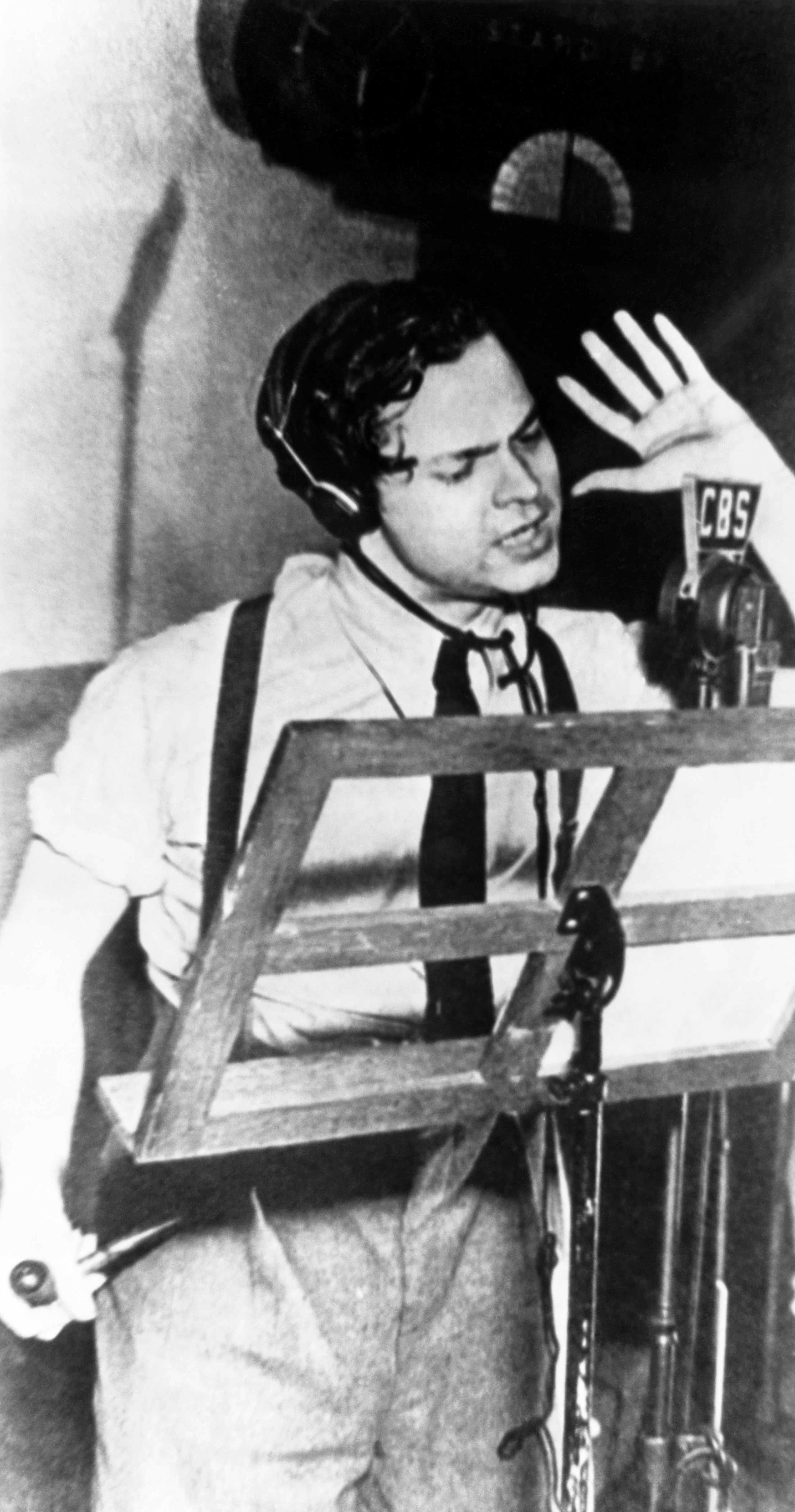 Orson Welles at a microphone during rehearsal for his 1938 War of the Worlds radio broadcast