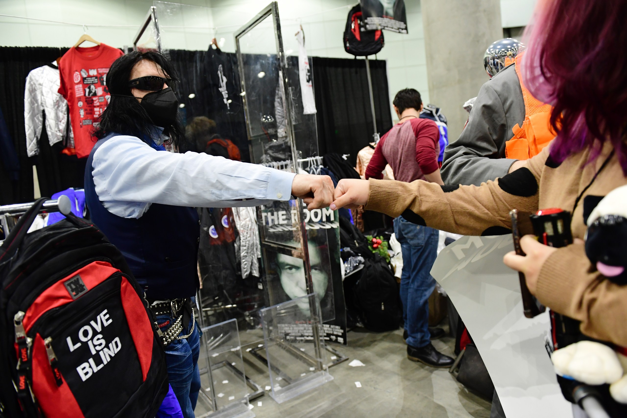Tommy Wiseau fist bumping a fan at the 2021 Los Angeles Comic Con